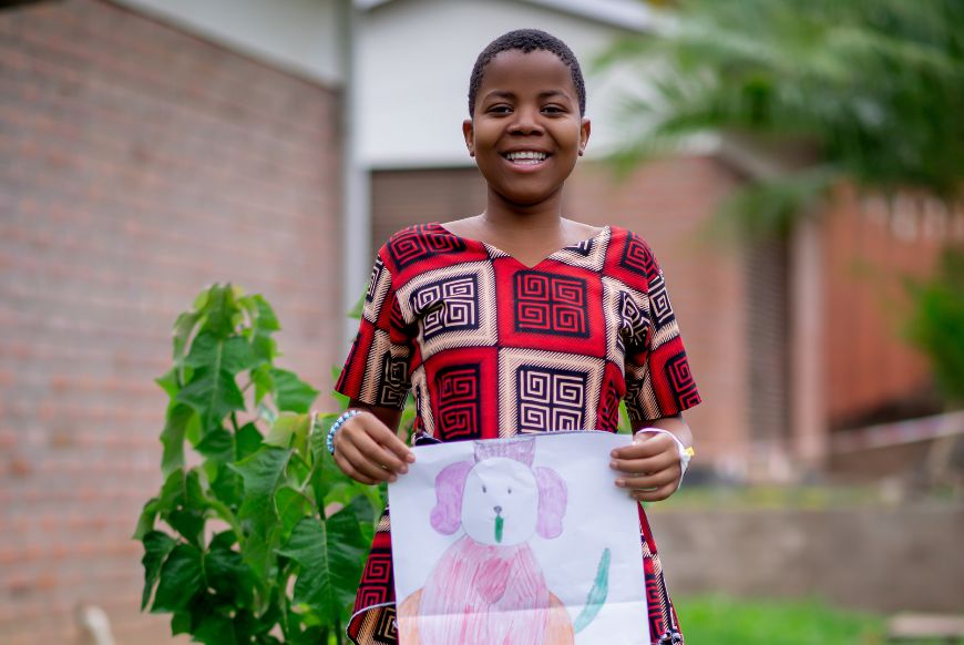 Child holding a drawing of a dog